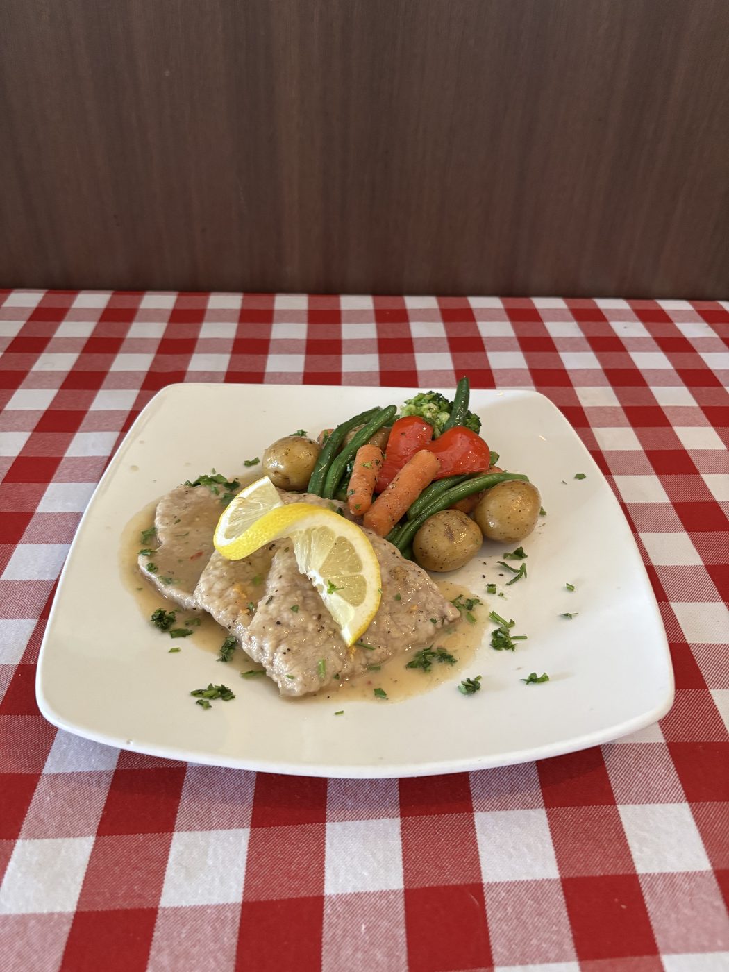 Veal medallions in lemon sauce with potatoes and vegetables